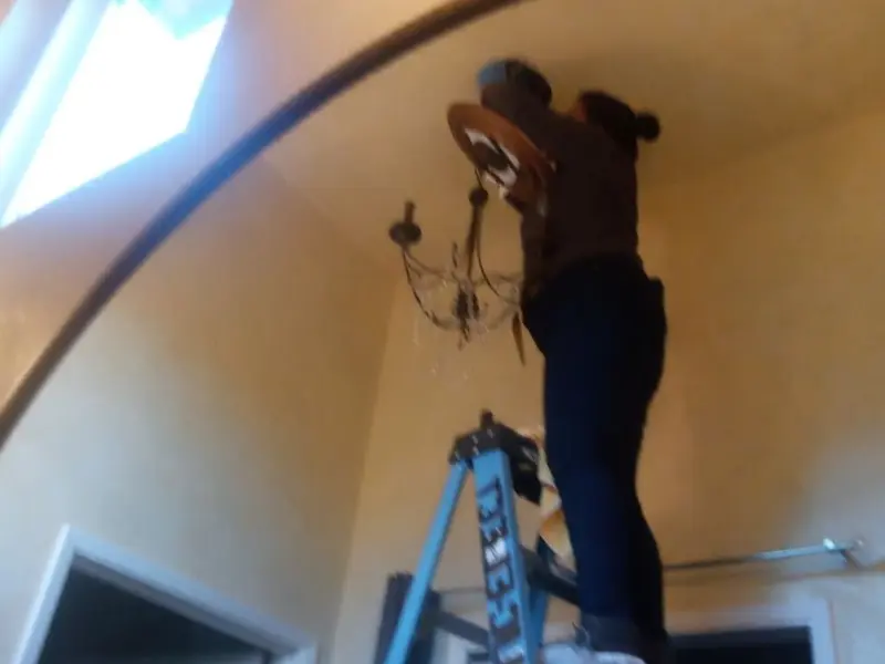 Electrician installing a chandelier in a Scotts Valley residence